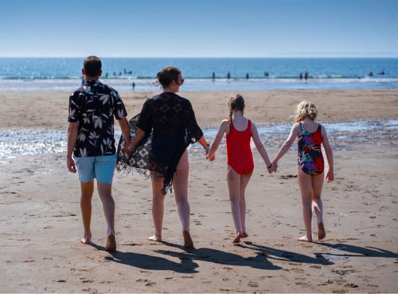 Family walking on Croyde Beach in the summer